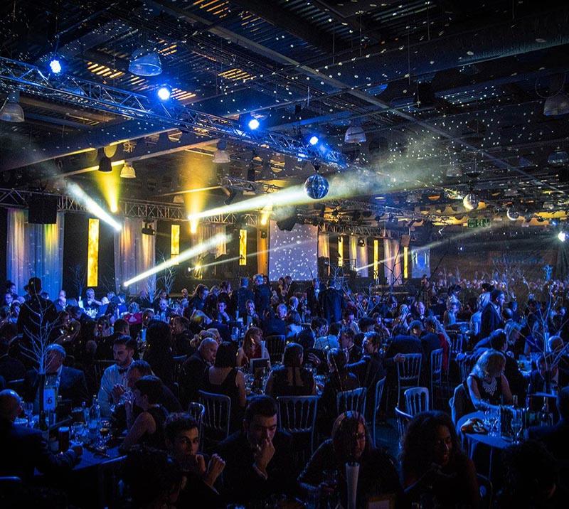 A room full of partygoers enjoying the music and light show.