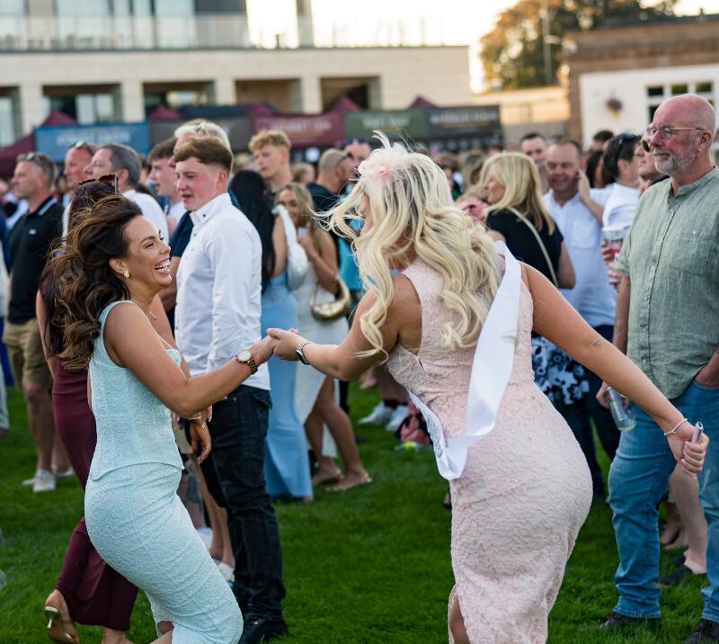 Two race goers having a great time dancing at Doncaster Racecourse