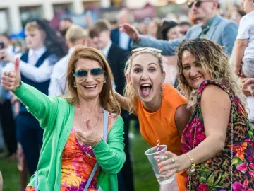 Three women in the crowd at Doncaster Races enjoy the entertainment