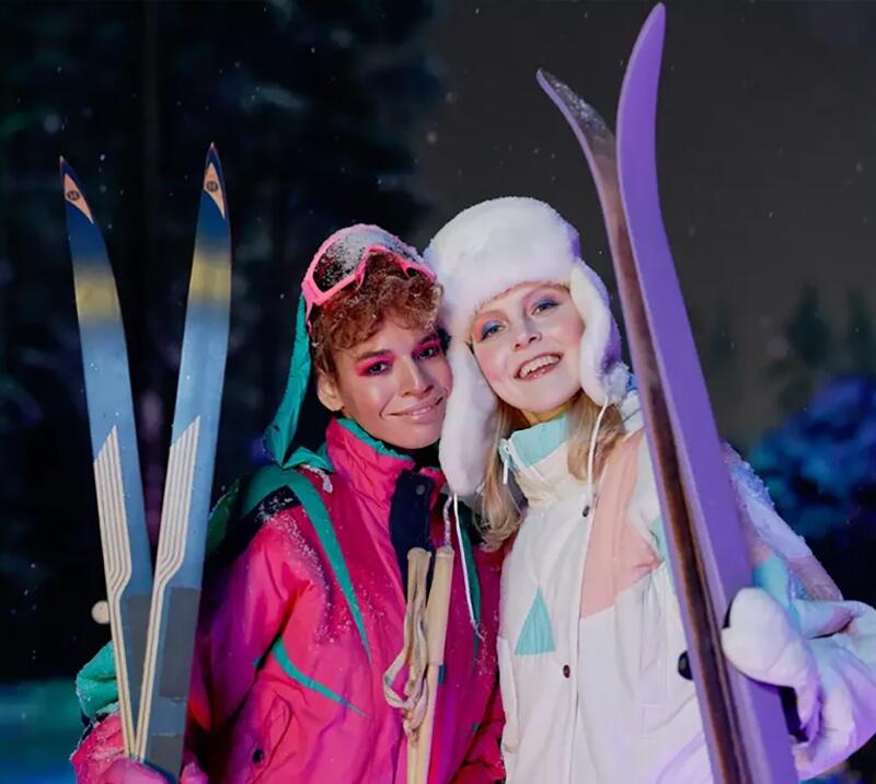 Two people dressed up in ski gear 