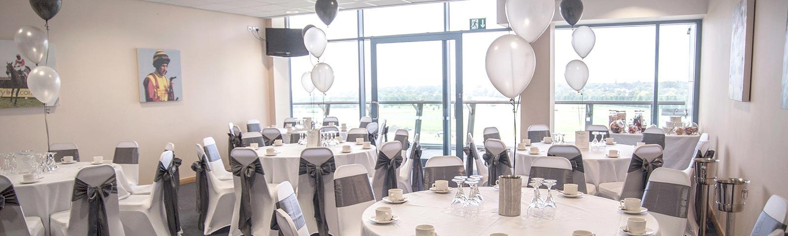 A suite at Doncaster Racecourse set for a party with balloons on tables