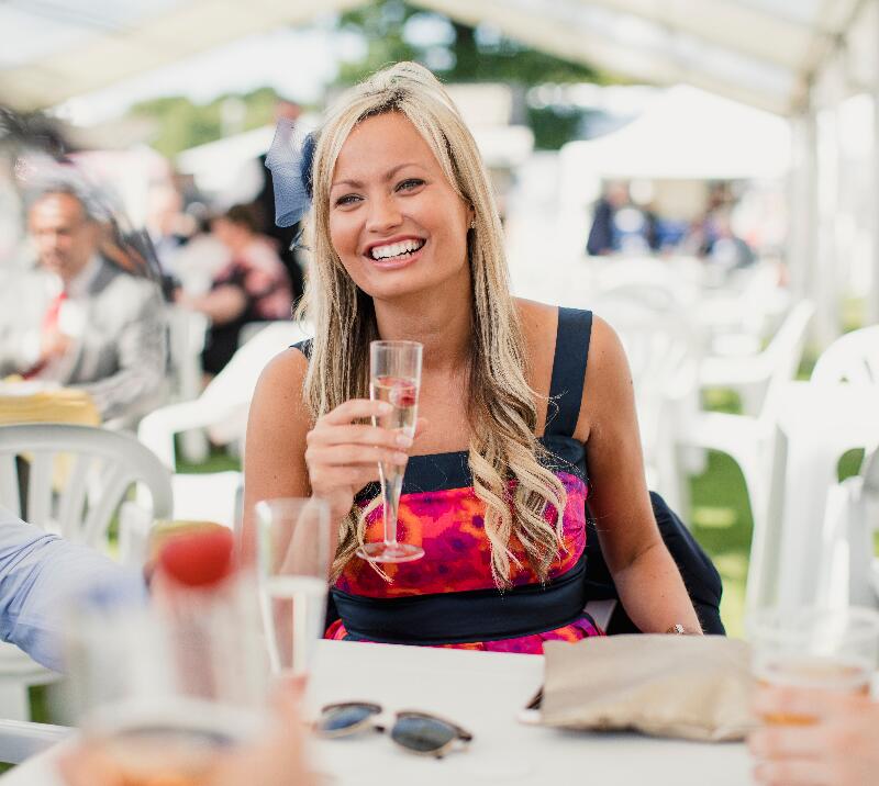 A lady at a table drinking champagne.