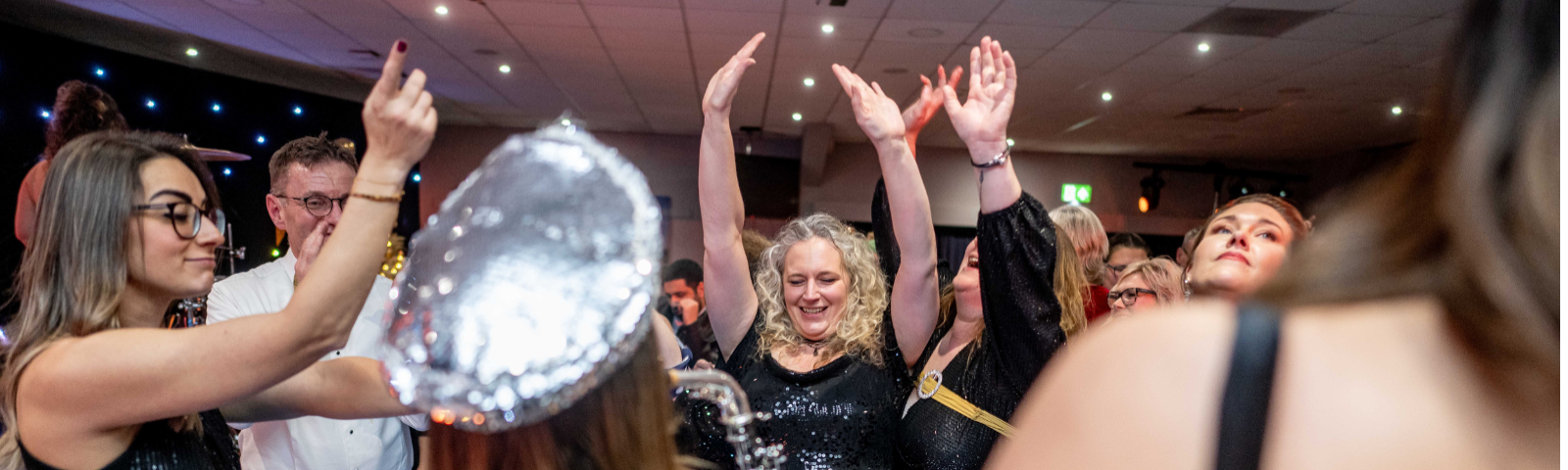 People smiling and dancing at Doncaster Shared Christmas Party Nights.