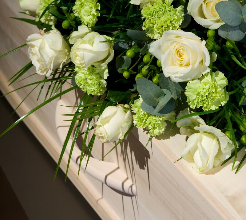 A bouquet of flowers sit ontop of a casket