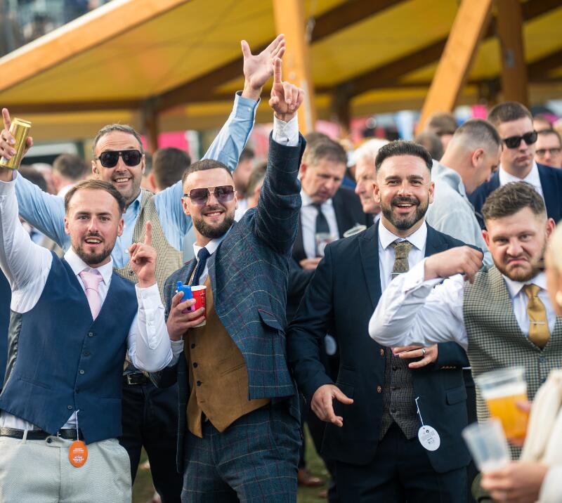 A group of men wearing suits partying together at the St Leger Festival on Cup Day.