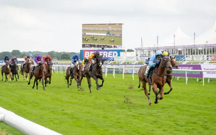 Horses racing towards the finish at Doncaster Racecourse