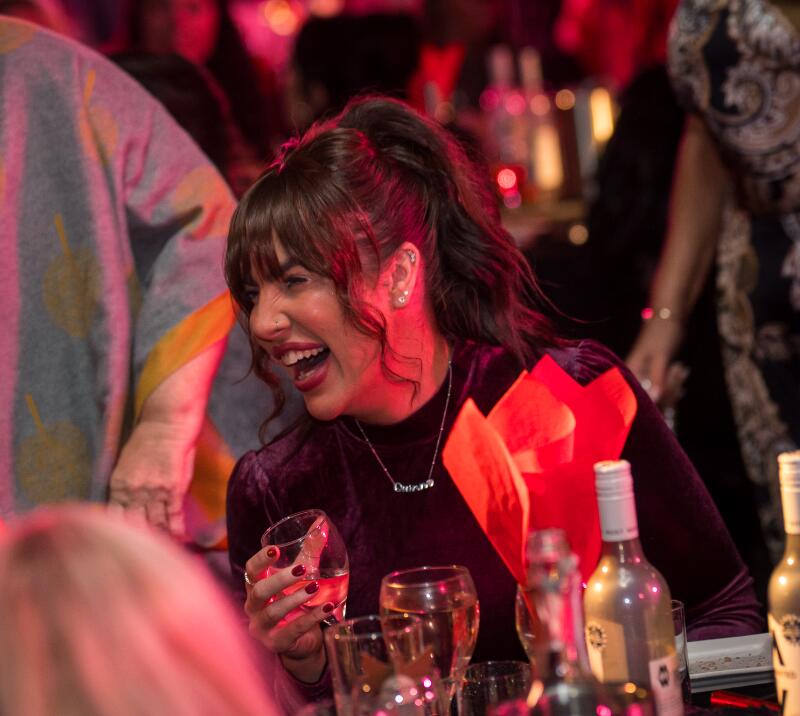 A woman laughing at a Christmas party 