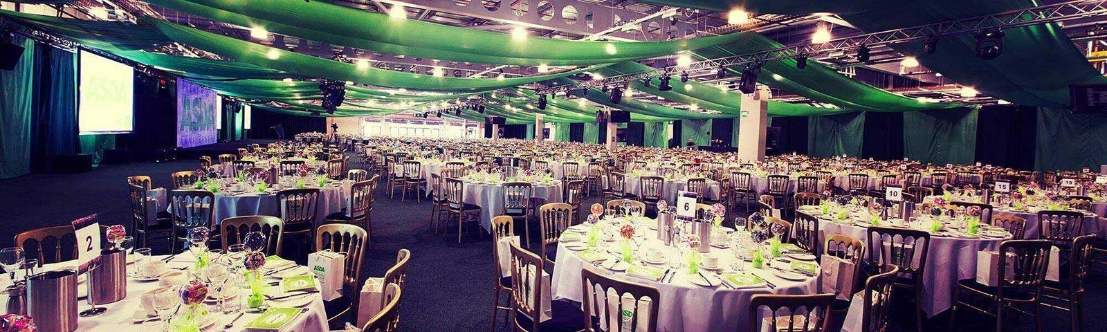 A large hall with a large amount of tables all prepared for exhibition guests.